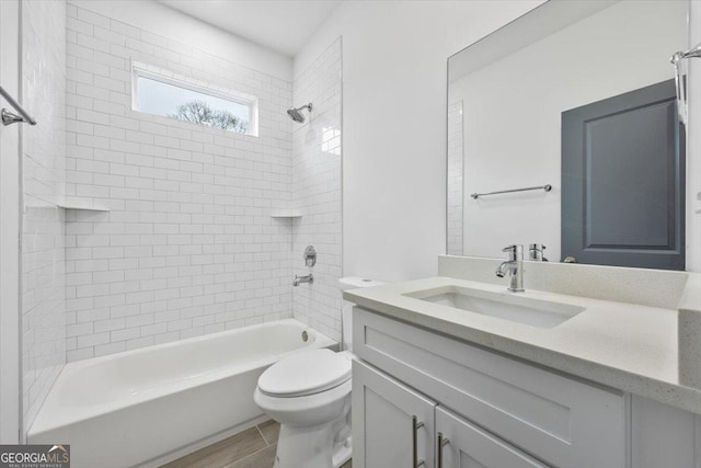 full bathroom with toilet, vanity, tiled shower / bath combo, and hardwood / wood-style flooring