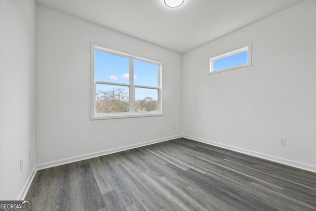 unfurnished room with dark wood-type flooring