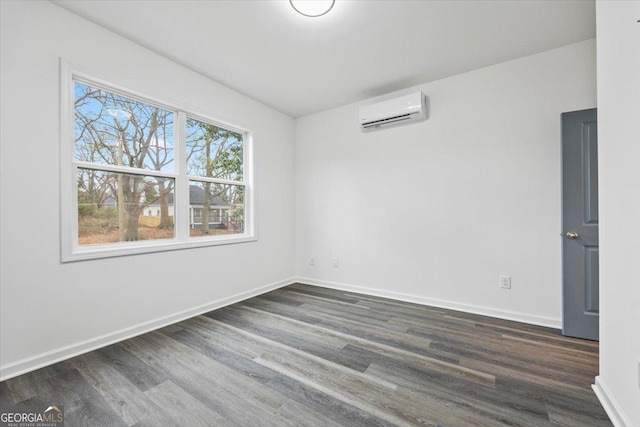 spare room with an AC wall unit and dark hardwood / wood-style floors