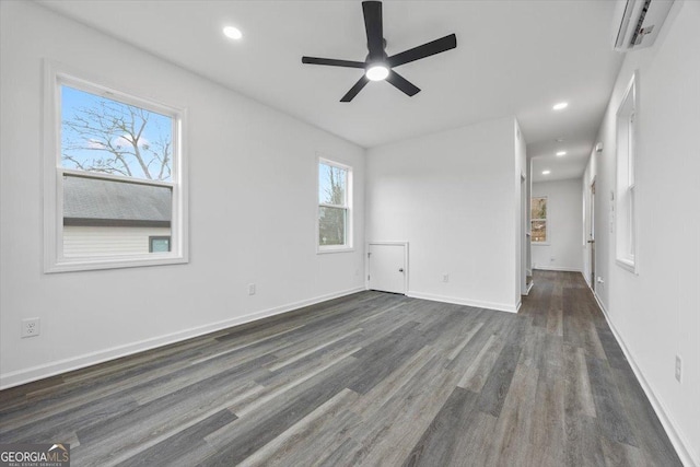 unfurnished room featuring ceiling fan, dark hardwood / wood-style flooring, and a wall mounted air conditioner