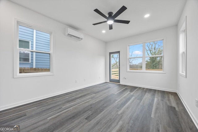 spare room with ceiling fan, an AC wall unit, and dark wood-type flooring