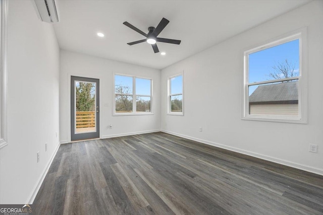 spare room with ceiling fan, dark hardwood / wood-style floors, and a wall mounted AC