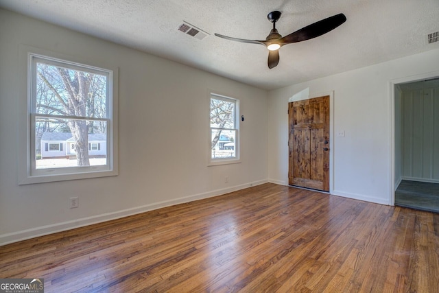 unfurnished bedroom featuring ceiling fan, a textured ceiling, and dark hardwood / wood-style flooring