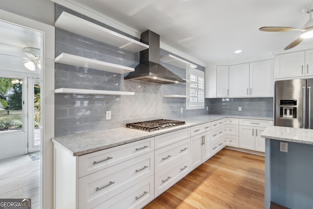 kitchen with white cabinetry, stainless steel appliances, ceiling fan, and island exhaust hood