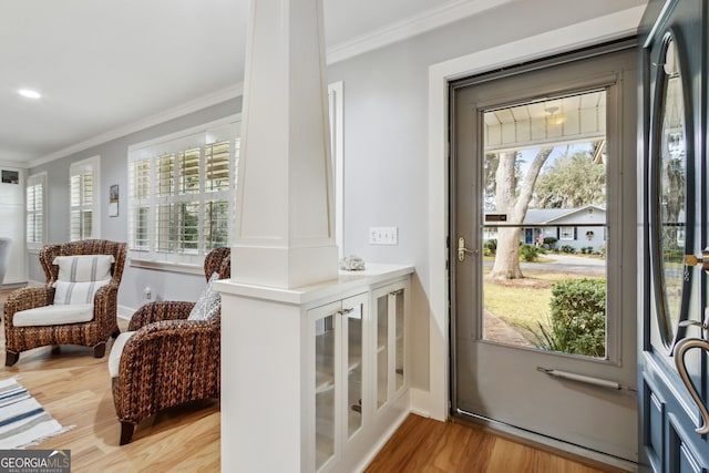 doorway to outside with crown molding and light hardwood / wood-style floors