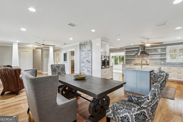 dining space featuring ornamental molding, light hardwood / wood-style floors, and ceiling fan