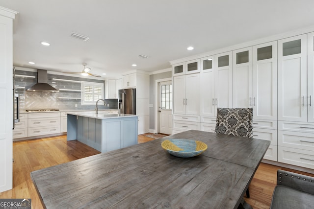 interior space with ceiling fan, sink, and light wood-type flooring