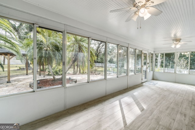 unfurnished sunroom featuring ceiling fan