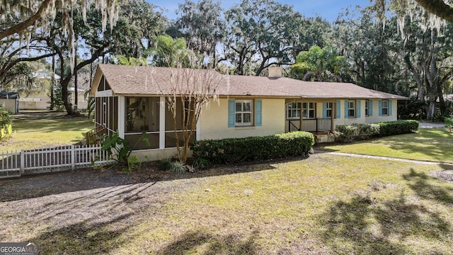 single story home featuring a front lawn and a sunroom