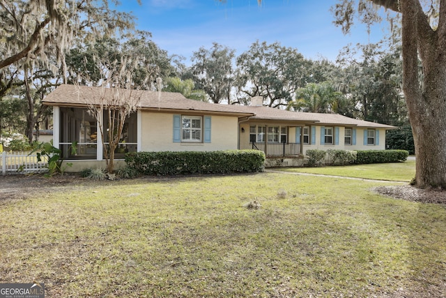 single story home with a sunroom and a front yard