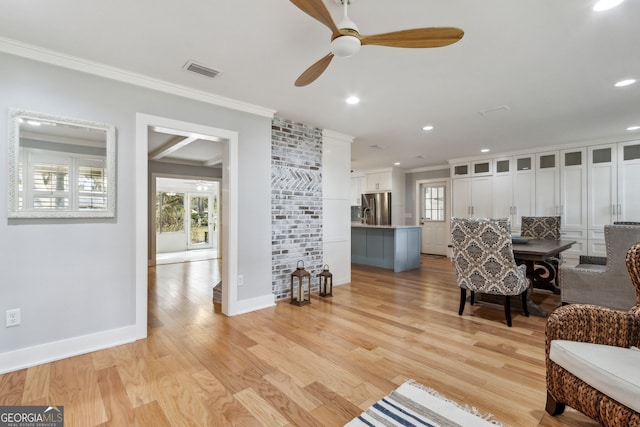 living room with crown molding, ceiling fan, and light hardwood / wood-style flooring