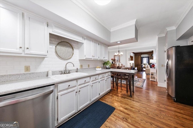 kitchen featuring white cabinetry, appliances with stainless steel finishes, backsplash, hanging light fixtures, and sink