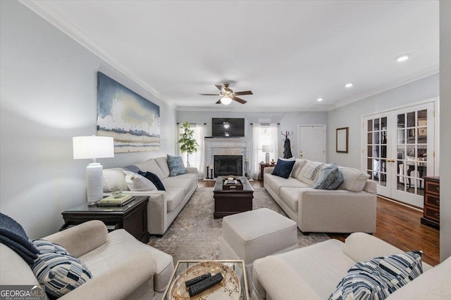 living room with dark wood-type flooring, crown molding, french doors, and ceiling fan