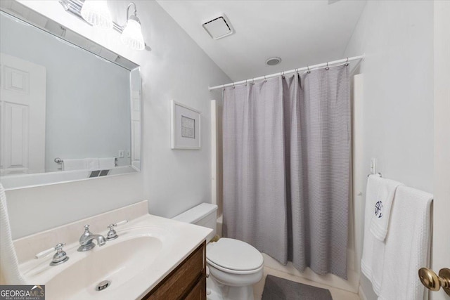 bathroom featuring toilet, tile patterned flooring, vaulted ceiling, and vanity