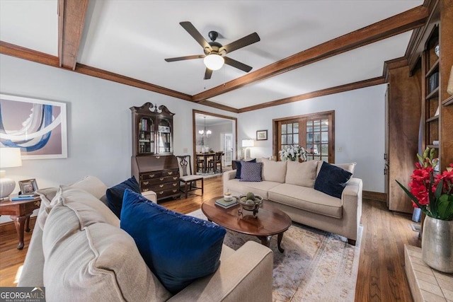 living room featuring light wood-type flooring, ceiling fan with notable chandelier, and beam ceiling