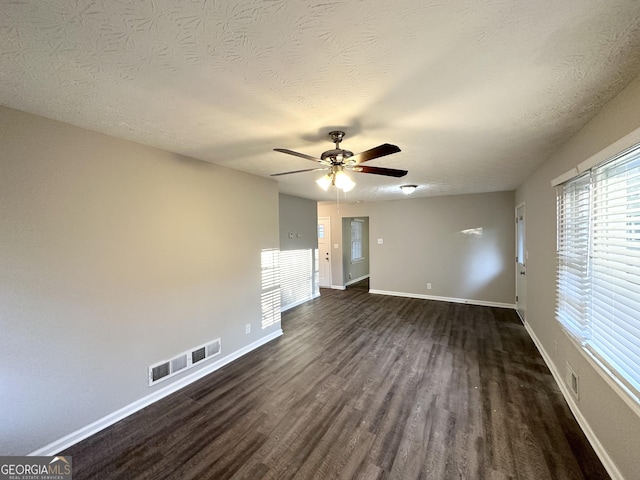 unfurnished room featuring ceiling fan, a textured ceiling, and dark hardwood / wood-style flooring