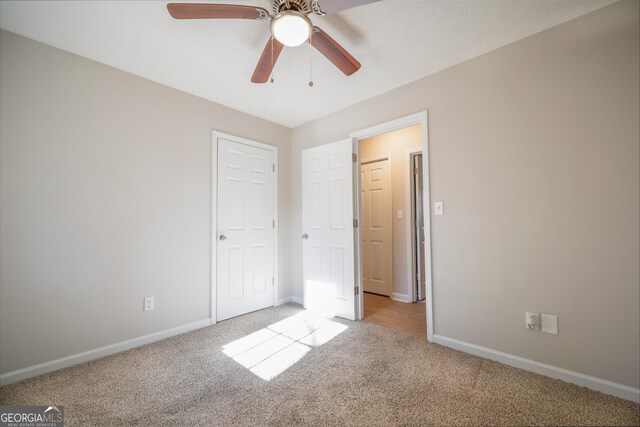 carpeted spare room with ceiling fan