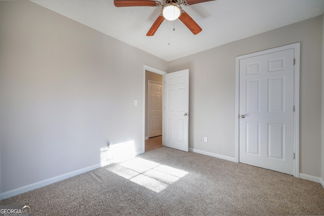 unfurnished room with ceiling fan and carpet flooring