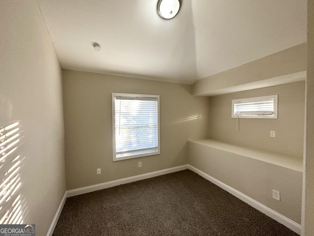 carpeted spare room featuring lofted ceiling