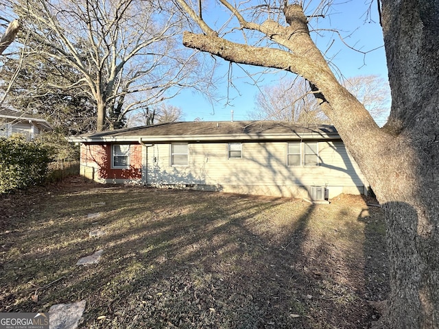 exterior space with central AC unit and a yard