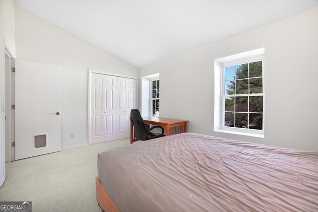 hallway featuring lofted ceiling and light colored carpet