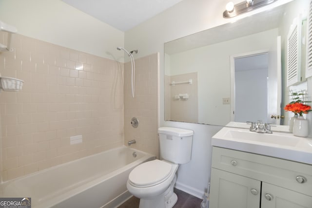 full bathroom featuring tiled shower / bath, vanity, and toilet