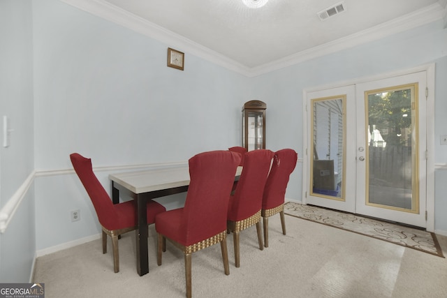 carpeted dining room with crown molding and french doors