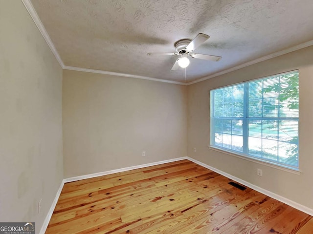 unfurnished room with ceiling fan, a textured ceiling, ornamental molding, and light wood-type flooring