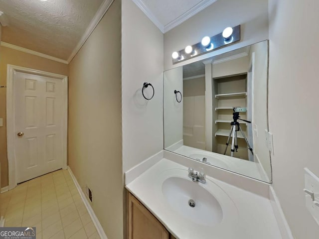 bathroom featuring a textured ceiling, tile patterned flooring, crown molding, and vanity