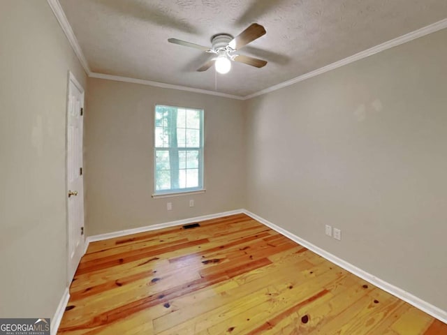 empty room with ceiling fan, a textured ceiling, ornamental molding, and hardwood / wood-style floors