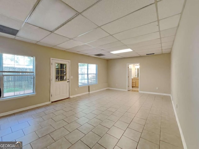 tiled spare room with a drop ceiling