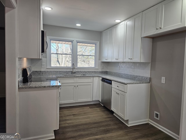 kitchen featuring light stone countertops, appliances with stainless steel finishes, white cabinetry, dark hardwood / wood-style flooring, and sink