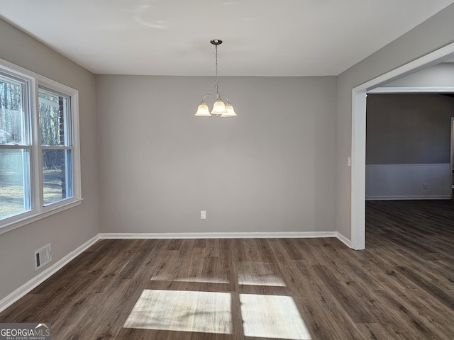 unfurnished room with dark hardwood / wood-style floors and a chandelier