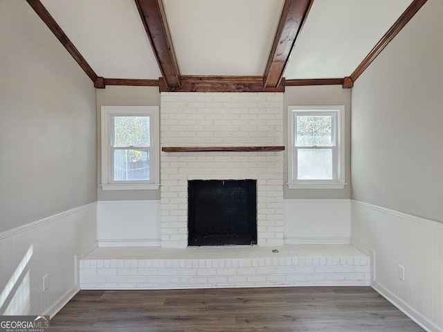 interior space with hardwood / wood-style floors, beam ceiling, and a fireplace