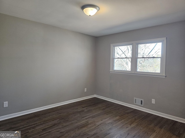 spare room featuring dark hardwood / wood-style flooring