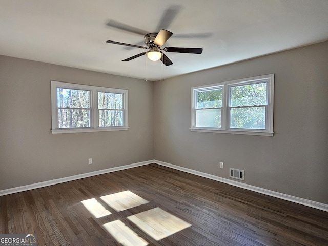 empty room with ceiling fan and dark hardwood / wood-style floors