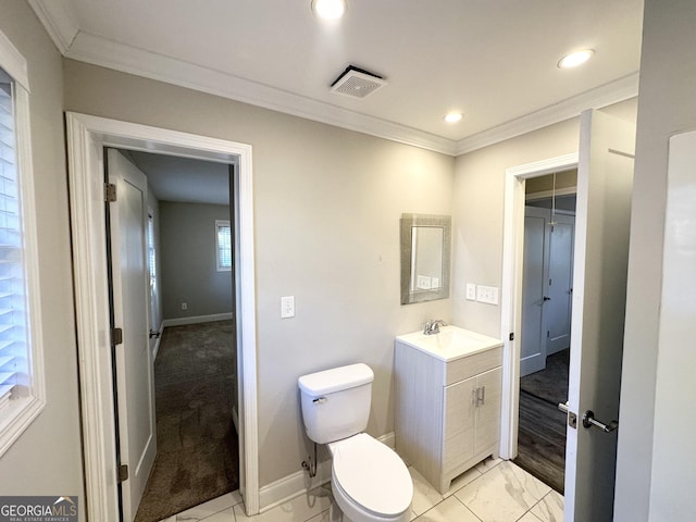 bathroom featuring toilet, vanity, and ornamental molding