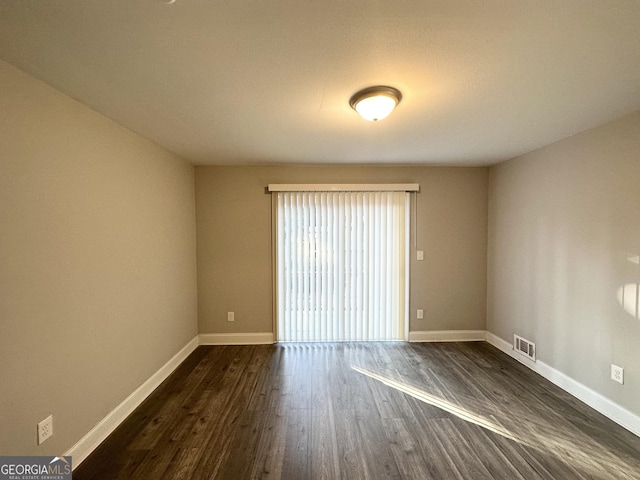 unfurnished room featuring dark wood-type flooring