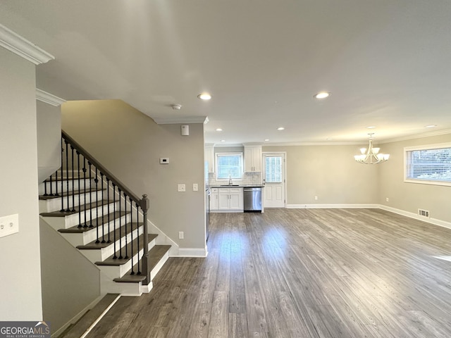 unfurnished living room with a chandelier, sink, ornamental molding, and hardwood / wood-style flooring