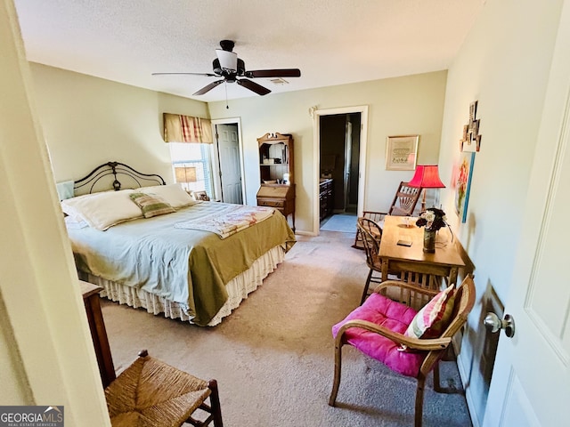 bedroom featuring a textured ceiling, ceiling fan, carpet floors, and ensuite bath