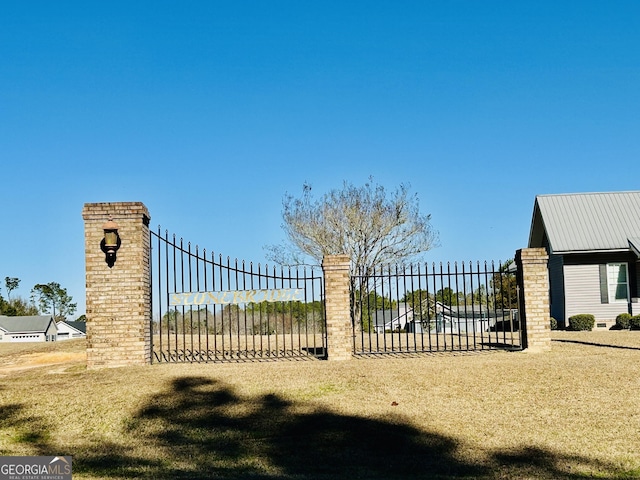 view of gate featuring a lawn