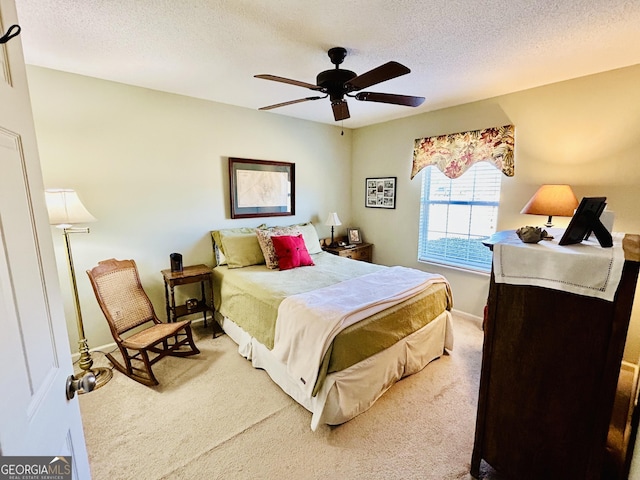 bedroom featuring a textured ceiling, ceiling fan, and carpet floors