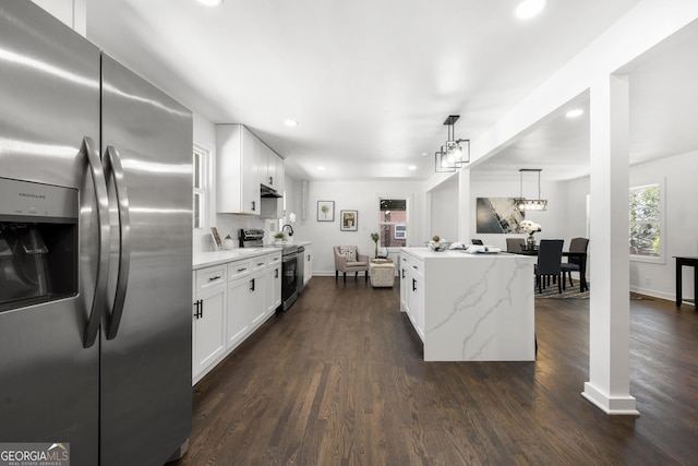 kitchen with stainless steel appliances, white cabinetry, tasteful backsplash, and decorative light fixtures