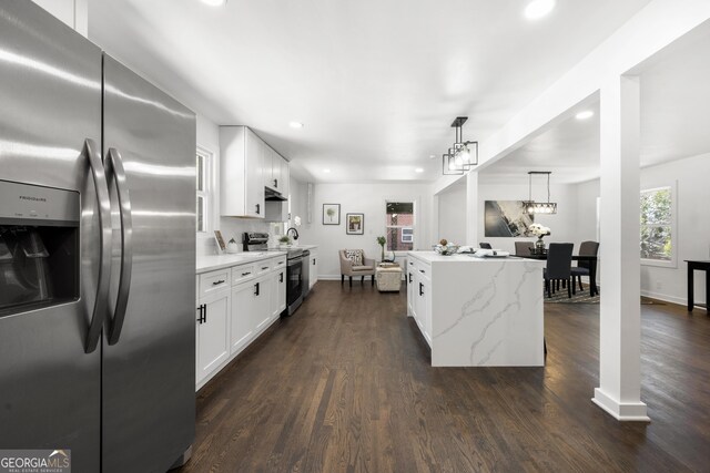 kitchen featuring white cabinets, stainless steel range with electric cooktop, dark wood-type flooring, sink, and hanging light fixtures