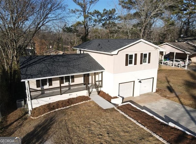 view of front of property with a front yard, a garage, and a porch