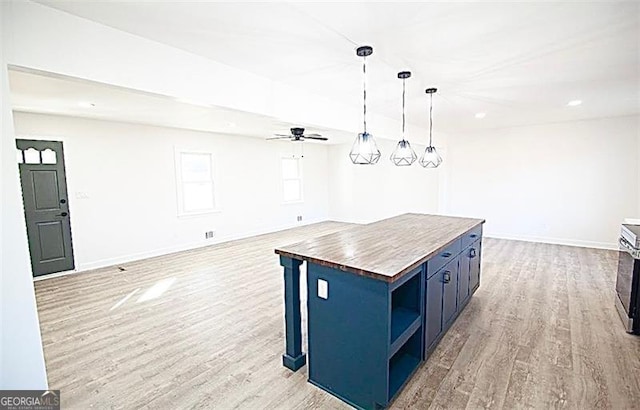 kitchen featuring pendant lighting, light hardwood / wood-style floors, butcher block countertops, a center island, and blue cabinetry