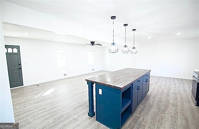 kitchen with wooden counters, a center island, light hardwood / wood-style flooring, hanging light fixtures, and blue cabinets