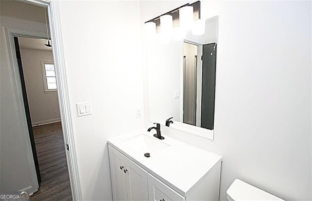 bathroom featuring toilet, wood-type flooring, and vanity