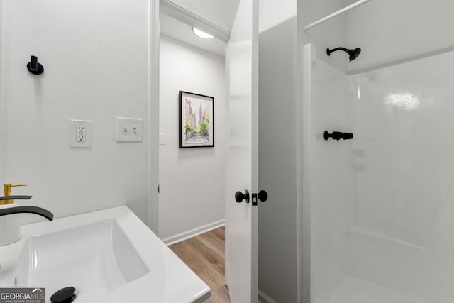 bathroom with a shower and hardwood / wood-style floors