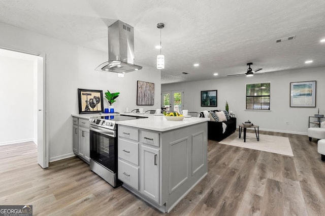 kitchen featuring island exhaust hood, stainless steel range with electric cooktop, pendant lighting, and a textured ceiling